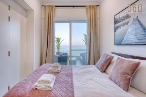 a bedroom with a bed with a view of the ocean at 2BR Seafront Elegance with Balcony & Sea Views by 360 Estates in St. Paul's Bay