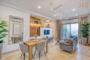 a dining room and living room with a table and chairs at 2BR Seafront Elegance with Balcony & Sea Views by 360 Estates in St. Paul's Bay