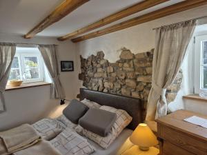 a bedroom with a bed and a stone wall at Rechenpeterhäusle in Fischerbach