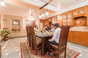 a group of people sitting around a table in a kitchen at FabHotel Pink Cozzy in Jaipur