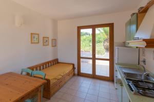 a kitchen with a bed and a table in a room at Villa Le Palme 3 - 4 in Casa Buraccio