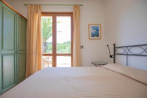 a bedroom with a bed and a large window at Villa Le Palme 3 - 4 in Casa Buraccio