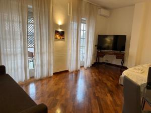 a living room with wooden floors and a flat screen tv at Sparano Top Class 7 in Bari
