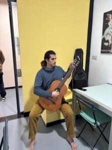 a man sitting on a chair playing a guitar at SEVILLE YOUR WAY in Seville