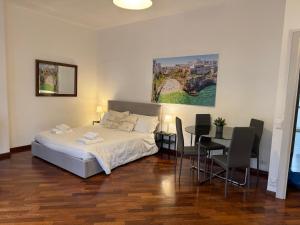 a bedroom with a bed and a table and chairs at Sparano Top Class 7 in Bari