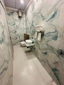 a bathroom with a marble wall with a sink at Hotel The Maya Palace in Jaipur