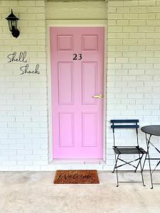 a pink door on a house with a table at Shell Shack in Tomakin