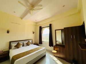 a bedroom with a large bed and a window at Hotel The Maya Palace in Jaipur