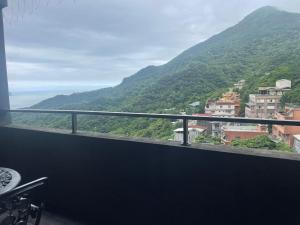 a balcony with a view of a mountain at Night Sea Homestay in Jiufen