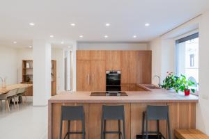 a kitchen with wooden cabinets and a island with bar stools at Relais La Torre - Domus Verona in Verona