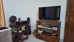 a living room with a flat screen tv and a book shelf at Casa Areca in Cheruthuruthi