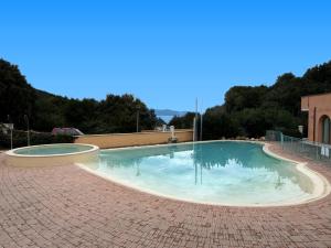 a large swimming pool on a brick patio at La Pergola Bilocale 6 - Cavo in Cavo