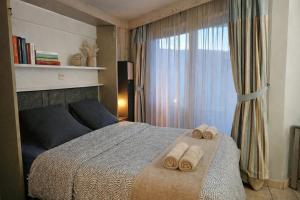 a bedroom with a bed with two towels on it at Reflets du Lac Annecy, Baie des Voiles - Vue Lac - Terrasse - Plage & Parking Privés in Duingt
