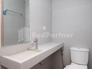 a white bathroom with a sink and a toilet at Mora Stay Demangan RedPartner in Yogyakarta +42 photos