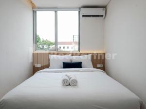 a bedroom with a large bed with two towels on it at Mora Stay Demangan RedPartner in Yogyakarta