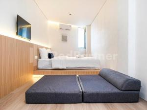 a bedroom with a bed in the corner of a room at Mora Stay Demangan RedPartner in Yogyakarta
