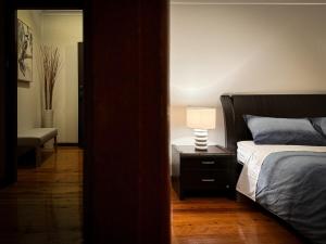 a bedroom with a bed and a lamp on a night stand at Old Charm Guesthouse in Bass Hill