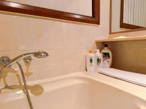 a bathroom with a bath tub with a shower at Old Charm Guesthouse in Bass Hill +4 photos