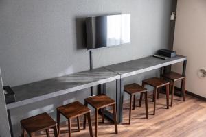 a bar with stools and a television on a wall at ReLA Kashiwa Eki Mae in Kashiwa