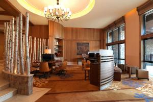 a lobby with a table and chairs and a chandelier at Sheraton Changbaishan Resort in Fusong