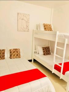 a bedroom with two bunk beds and a red rug at JULIA'S PLACE HOTEL Dangcagan - Bukidnon in Dancagan