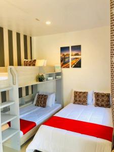 two bunk beds in a room with a red blanket at JULIA'S PLACE HOTEL Dangcagan - Bukidnon in Dancagan