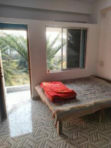 a room with a bed in front of a window at Laxmi Narasimha Hotel in mayapur +11 photos