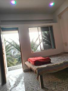 a room with two windows and a bench in front thereof at Laxmi Narasimha Hotel in mayapur