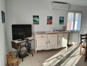 a living room with a flat screen tv and a table at Gite emilouise in Carnoules