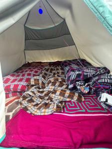 a bed in a tent with a blanket at Kedar cloud camp in Kedārnāth