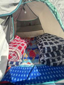 a tent with several blankets and pillows in it at Kedar cloud camp in Kedārnāth