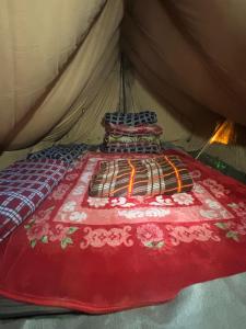 a bed in a tent with a red blanket at Kedar cloud camp in Kedārnāth