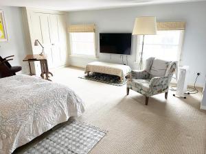 a bedroom with a bed and a chair and a tv at The Artist's House in Norwich