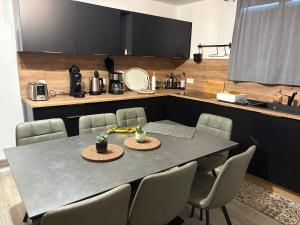 a dining room table with chairs and a kitchen at Alpes Ski SUPERDEVOLUY in Le Dévoluy