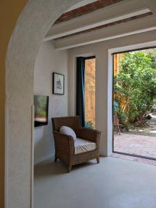 a wicker chair sitting in a room with a window at Ca la Lola Estartit in L'Estartit