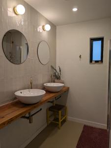 a bathroom with two sinks and two mirrors at Ca la Lola Estartit in L'Estartit