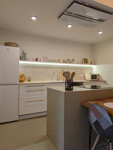 a kitchen with white cabinets and a refrigerator at Ca la Lola Estartit in L'Estartit +7 photos