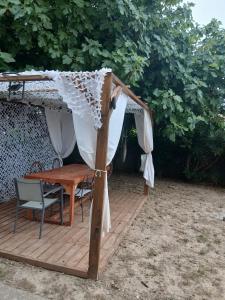 a gazebo with a table and chairs on a deck at Air-conditioned villa with pool in Mèze