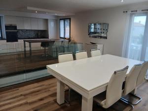 a dining room with a white table and chairs at Air-conditioned villa with pool in Mèze
