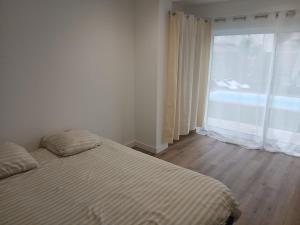 a bedroom with a bed and a large window at Air-conditioned villa with pool in Mèze +19 photos