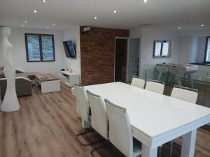 a dining room with a white table and chairs at Air-conditioned villa with pool in Mèze