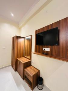 a room with a flat screen tv on a wall at Hotel The Maya Palace in Jaipur