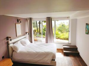 a bedroom with a white bed and a window at casa do campo in Machico