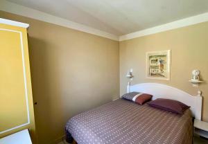 a bedroom with a bed with a purple comforter at Au calme, appartement au cœur du Golf - Piscine in Talmont