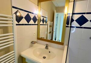 a bathroom with a sink and a mirror at Au calme, appartement au cœur du Golf - Piscine in Talmont +15 photos