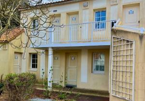 a building with a balcony on the side of it at Au calme, appartement au cœur du Golf - Piscine in Talmont