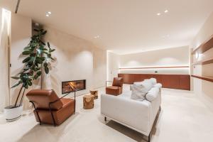 a living room with a white couch and a fireplace at Jerina Mansion by PikHost in Tirana +42 photos