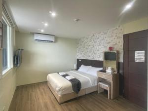 a hotel room with a bed and a television at Night Sea Homestay in Jiufen