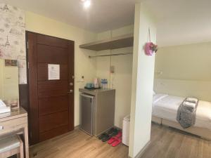 a small room with a bed and a door and a room with a bed at Night Sea Homestay in Jiufen
