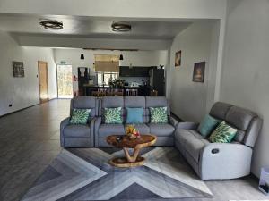 a living room with a couch and a table at Villa Soleil de L'Est in Petit Brûlé